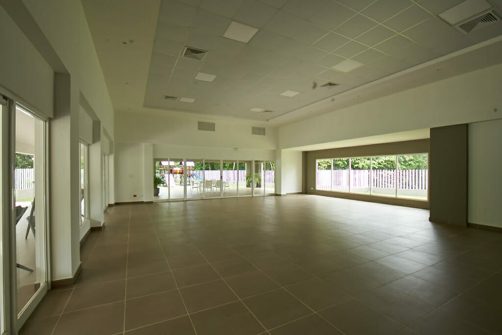 Sala de la planta baja con ventanas como amenidad del proyecto de apartamentos Península Norte en Panamá.