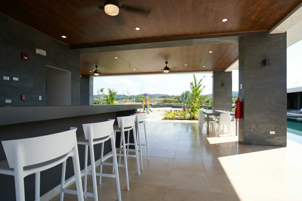 Mesa de bar con taburetes altos para refrescarse después de tomar el sol y nadar en la piscina.