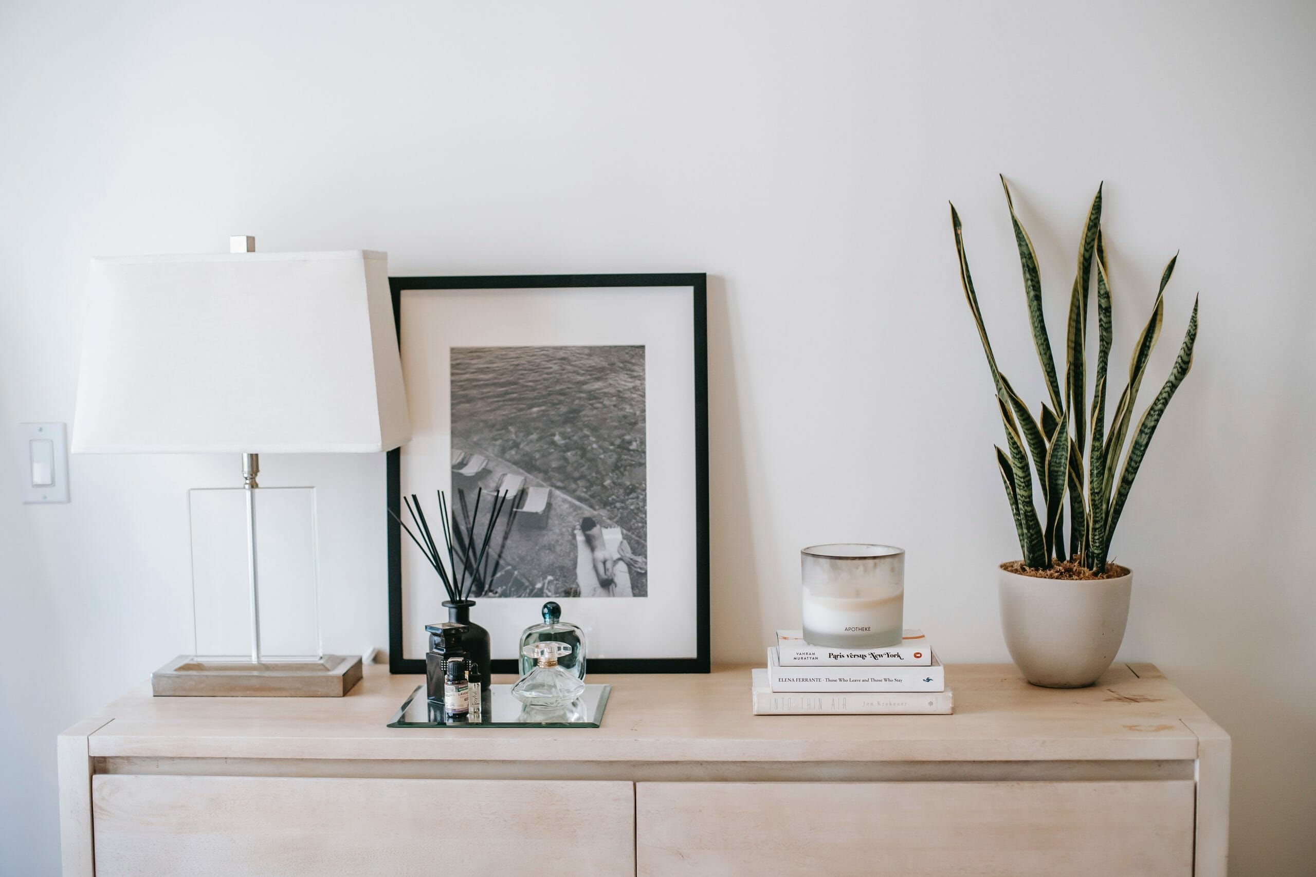 Mueble de casa con l&aacute;mpara, cuadro y maceta con planta.