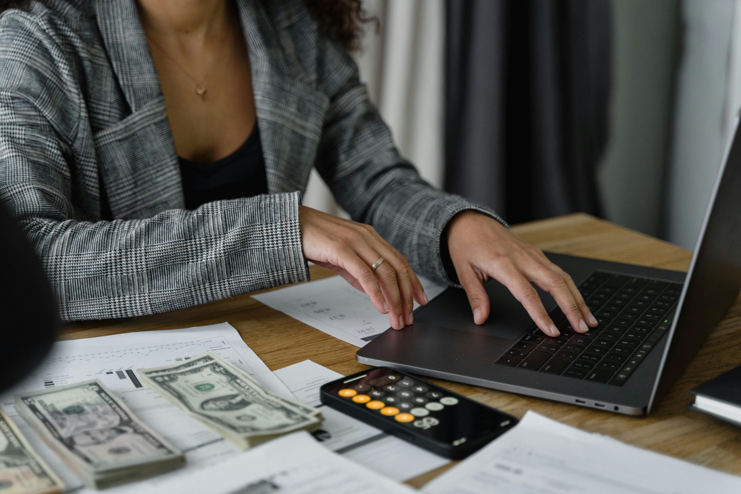 Mujer calculando pr&eacute;stamos hipotecarios en su computadora.