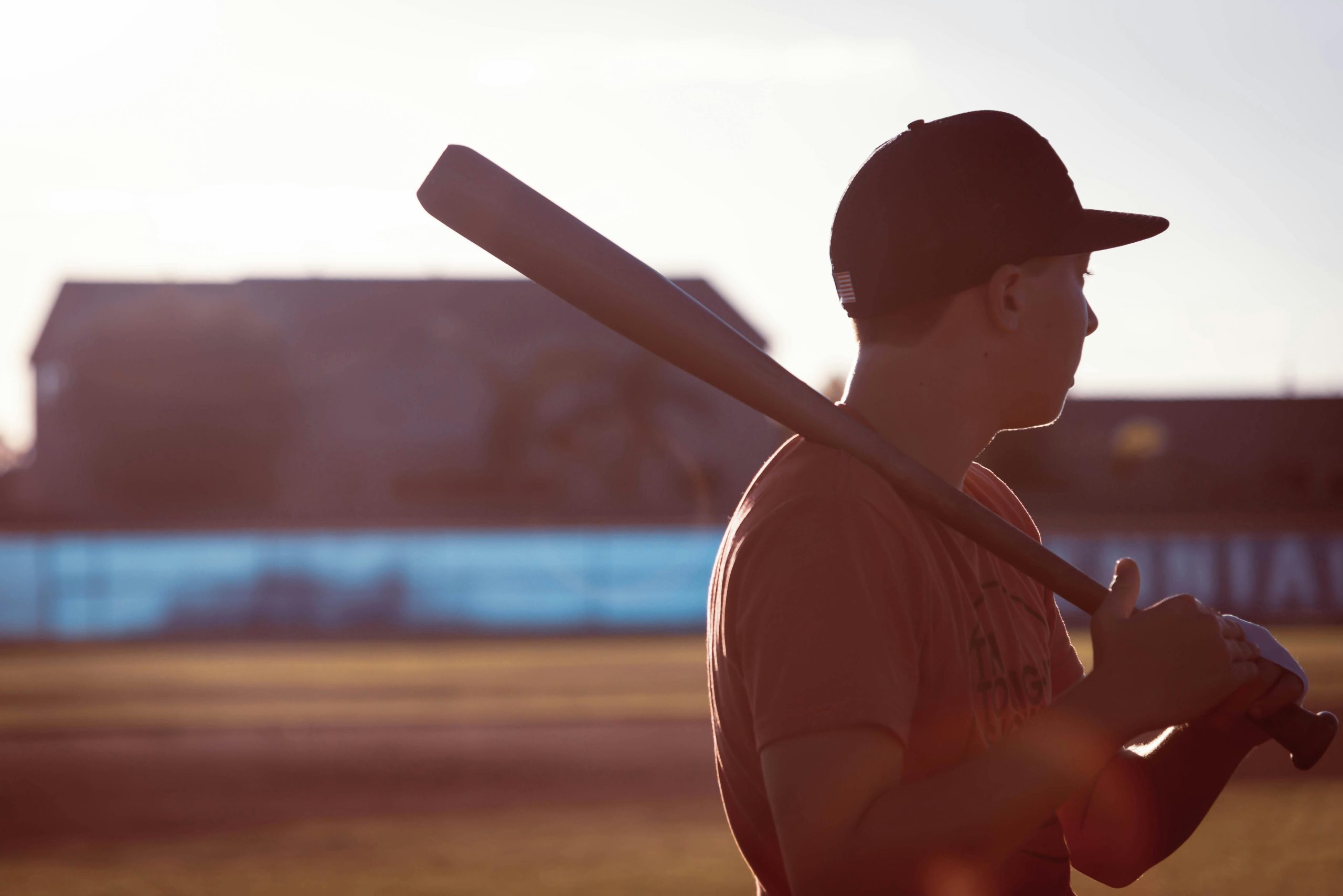  Joven jugador sosteniendo un bate de b&eacute;isbol en medio de un juego.