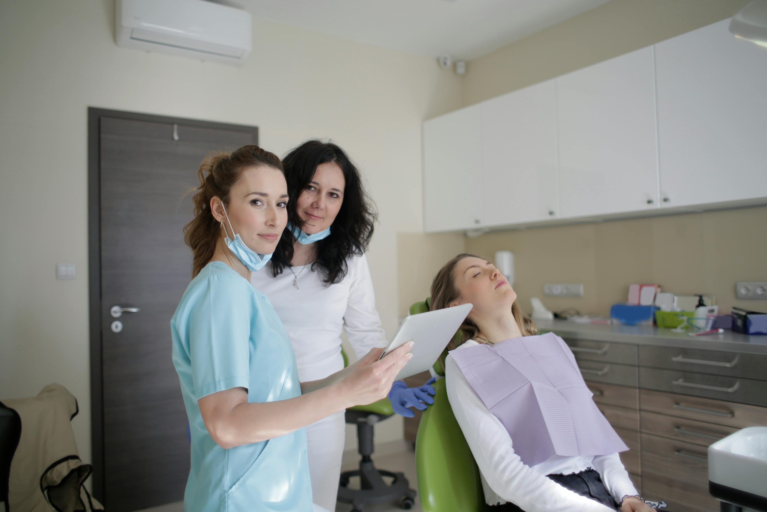 Personal m&eacute;dico con tableta y paciente acostado en cl&iacute;nica