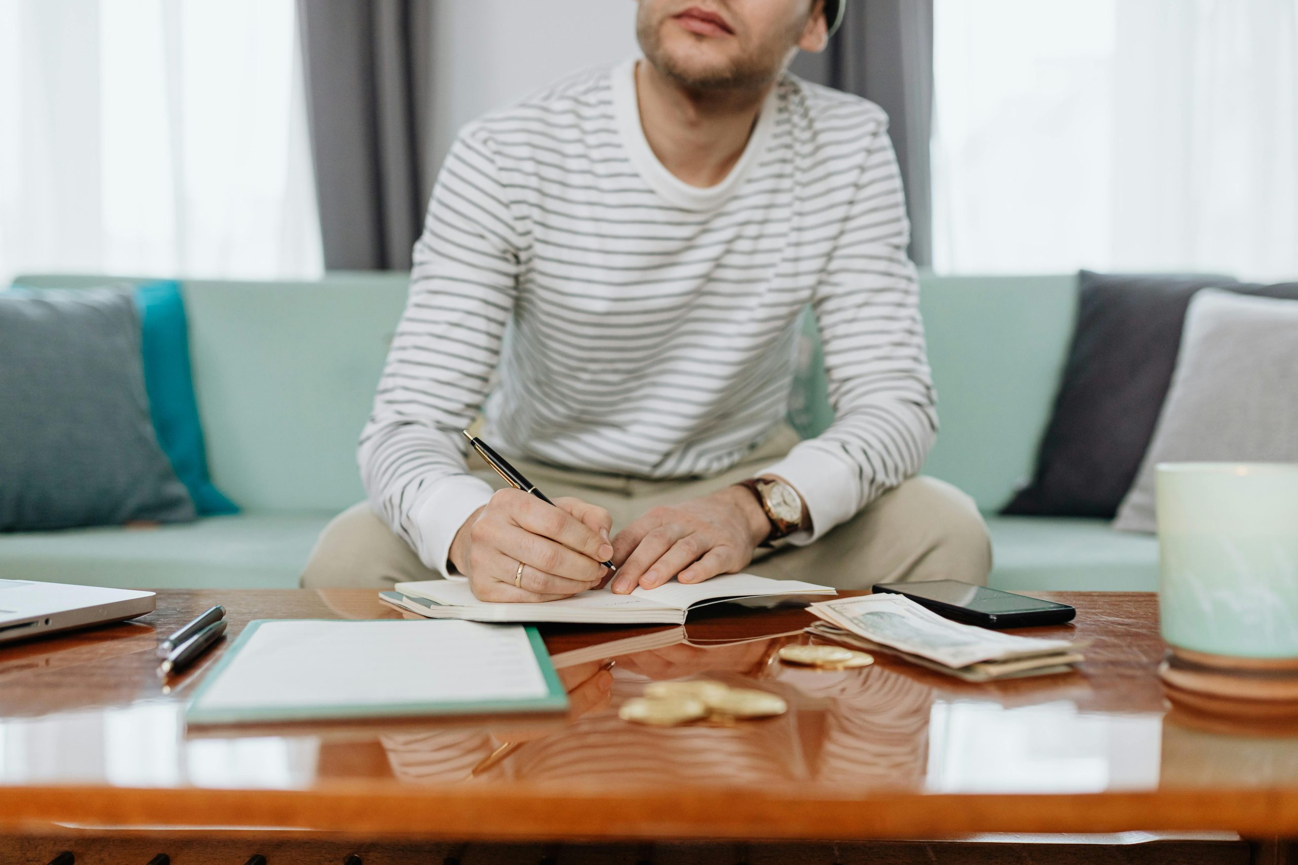 Joven haciendo c&aacute;lculos financieros en su cuaderno.