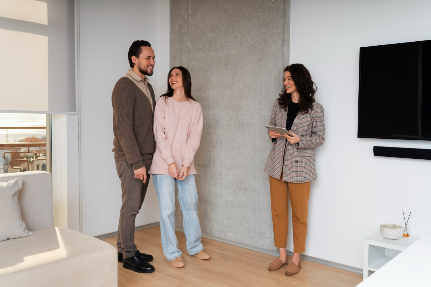 Clientes recorriendo un modelo de casa mostrada por agente inmobiliario